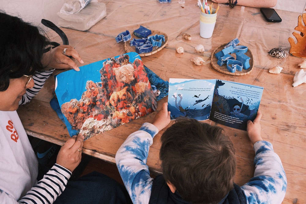 Parent and child exploring ocean conservation books together