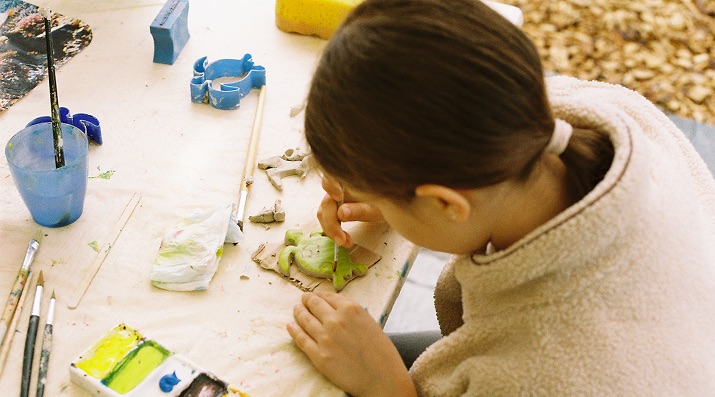 A child shaping a clay sea creature